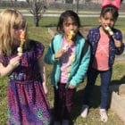 Kids eating rainbow fruit kabobs