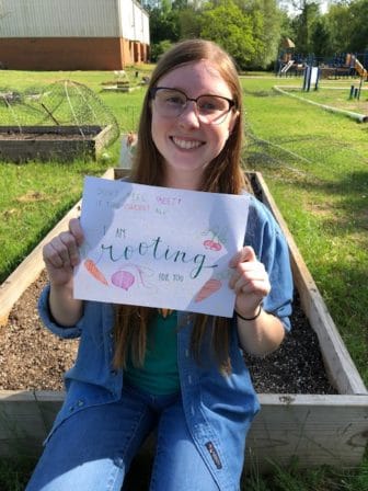 Katie Keith holds up a sign that reads "I'm rooting for you"