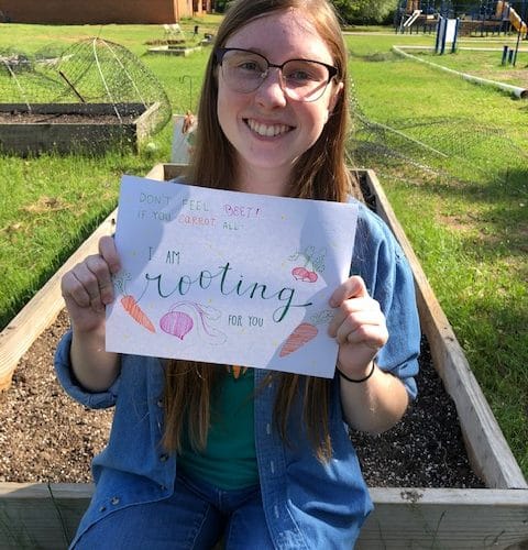 Katie Keith holds up a sign that reads "I'm rooting for you"